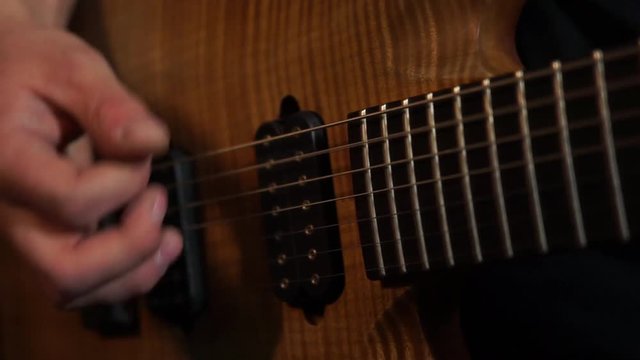 Playing guitar / Rock musician plays solo guitar. Close up of rock guitar solo. Closeup of rock guitar player hands. Rock guitarist. Young man playing electric guitar