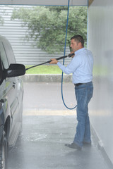 man washes foam machine carwash washing machine at the station