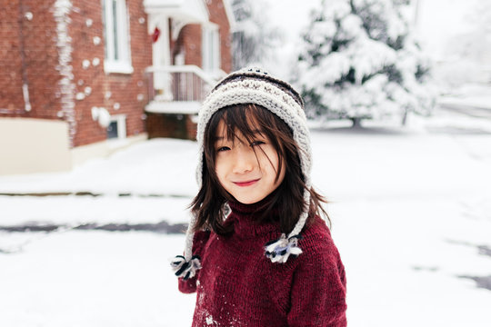 Young boy in winter hat smirks at camera