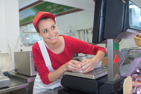 female cashier at sales desk of butcher