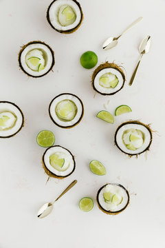Coconut shell halves with ice cream and lime wedges