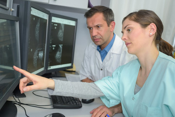 doctor and technician analyzing brain xrays on computer