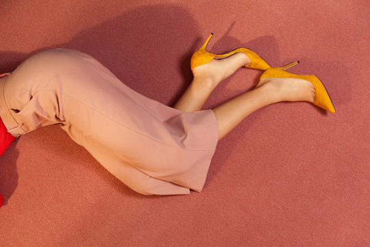 legs of a woman lying  down on the floor of a room