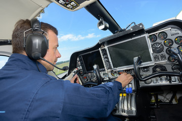rear view of confident male pilot sitting in cockpit