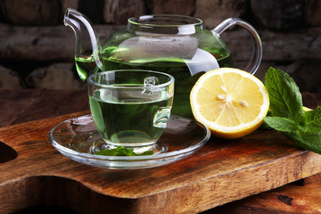 Cup of mint tea and leaves of mint on the table