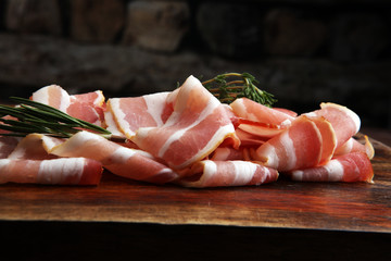 Raw sliced bacon with thyme leaves ready for cooking. - obrazy, fototapety, plakaty