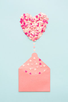 Pastel heart emerging from envelope