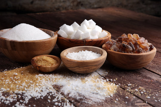 Various types of sugar, brown sugar and white on wooden table