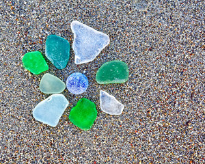 colorful glass pices polished by the sea on wet sand beach