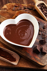 Chocolate cream melted and chocolate pieces on wooden table