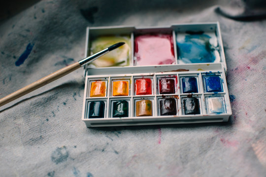 Palette of mini multicolored paints on a canvas