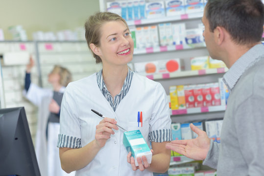 positive female pharmacist counseling customer