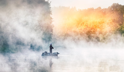 Fisherman boat in the morning fog. Beautiful dawn scenery on Seversky Donets river, Ukraine. Fishing background. Autumn season scenery.