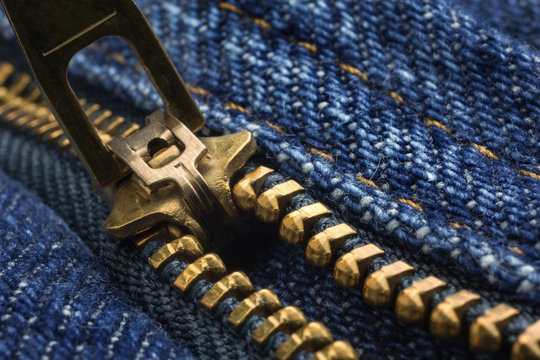 Partially open zipper on a pair of denim jeans.