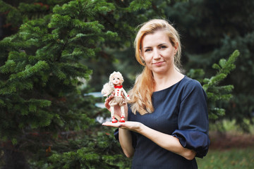 Obraz premium little smiling girl holding a doll in autumn park