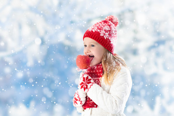 Child with candy apple on winter fair