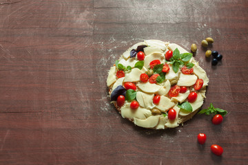 Raw vegetable tomato margarita pizza food on the Wood table with copy space.