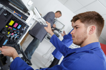 closeup shot young male technician repairing digital photocopier machine