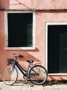 Bicycle outside pink house in Burano, Venice
