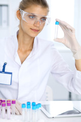 Female scientific researcher in laboratory studying substances or blood sample. Medicine and science concept