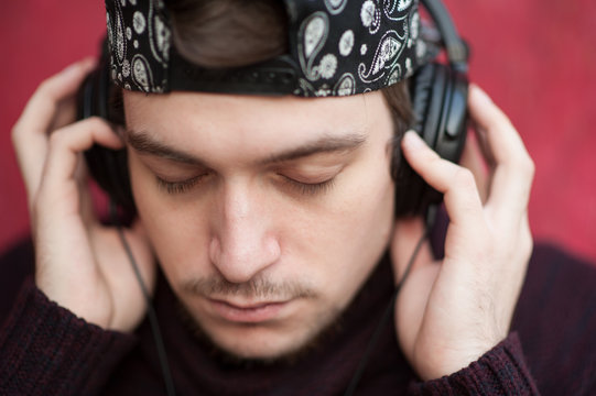 portrait of young man listening music through headphones