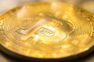 Macro photography of golden bitcoin with light spots.