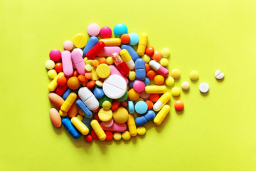 Fototapeta na wymiar Colorful pills on a green and yellow background