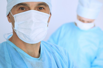 Fototapeta premium Boss surgeon is examining the operation while medical team are busy of patient. Medicine, healthcare and emergency in hospital