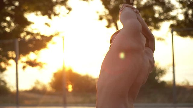 metis man with blond hair and naked torso making body slopes right and left training in sunrise time on nature slow motion 