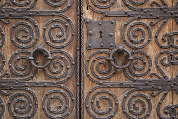 ancient brown wooden door with metallic ornaments