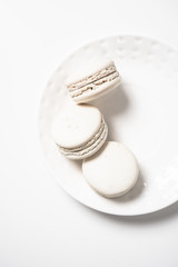 Three beige white macaroon cookies on plate