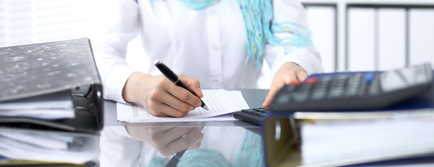 Female bookkeeper or financial inspector  making report, calculating or checking balance. Internal...