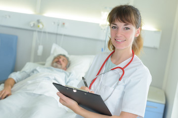 portrait of nurse holding file in hospital room