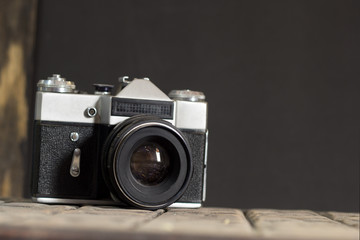 vintage old film camera opposite the black wall, copy space