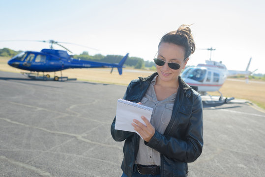 pretty pilot woman on helicopter background
