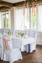 table serving with dishes and flowers in hall
