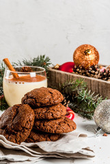Chocolate Crinkle cookies for Christmas, with eggnog cocktail, candy cane, Christmas tree and holiday decoration, on white marble table, copy space