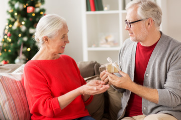 happy smiling senior couple with christmas gift