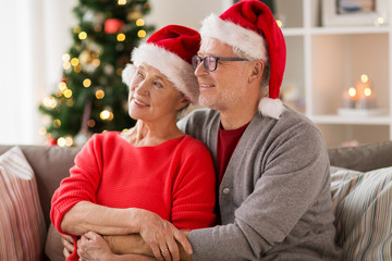 happy senior couple in santa hats at christmas