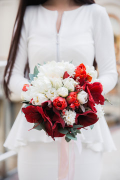 bride holding red wedding bouquet