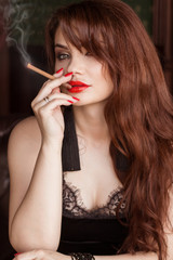 A beautiful sexy woman in a black dress smokes a cigarette and drinks whiskey. Mistress, Spy Girl