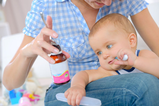 Mother holding baby's medicine bottle
