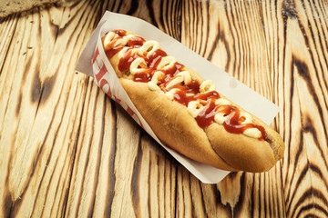 Barbecue Grilled Hot Dog with sauce,Hot Dog With Yellow Mustard,Onion,Pickles and French Fries,Tasty hot-dogs with vegetables on wooden background, close up,hot dogs with mustard, ketchup and relish