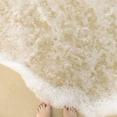 Sandstrand mit Brandung und Füßen