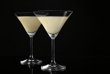 Glasses of lemon drop martini on black background