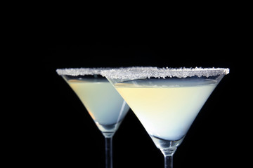 Glasses of lemon drop martini on black background