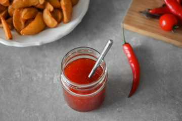 Glass jar with chili sauce on kitchen table