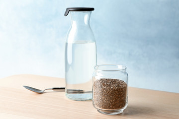 Chia seeds and bottle of water on wooden table