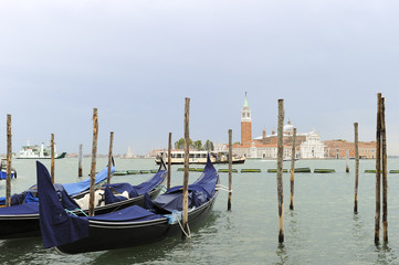 Fototapeta na wymiar Traditional gondolas in the sea water on background of ancient Venice, Italy