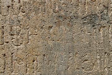 Texture of ancient stone wall with medieval writings of armenian monastery Geghard
